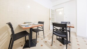 A dining area with two tables, chairs, and a bench.