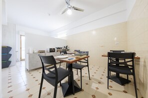 Une cuisine moderne avec un coin repas, comprenant une table avec des chaises, un four à micro-ondes et une machine à café.