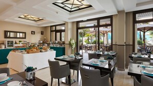 A modern dining area with a buffet, tables set for dining, and a view of the outdoor patio. - Honeymoon Suite in Cannes (Cannes)