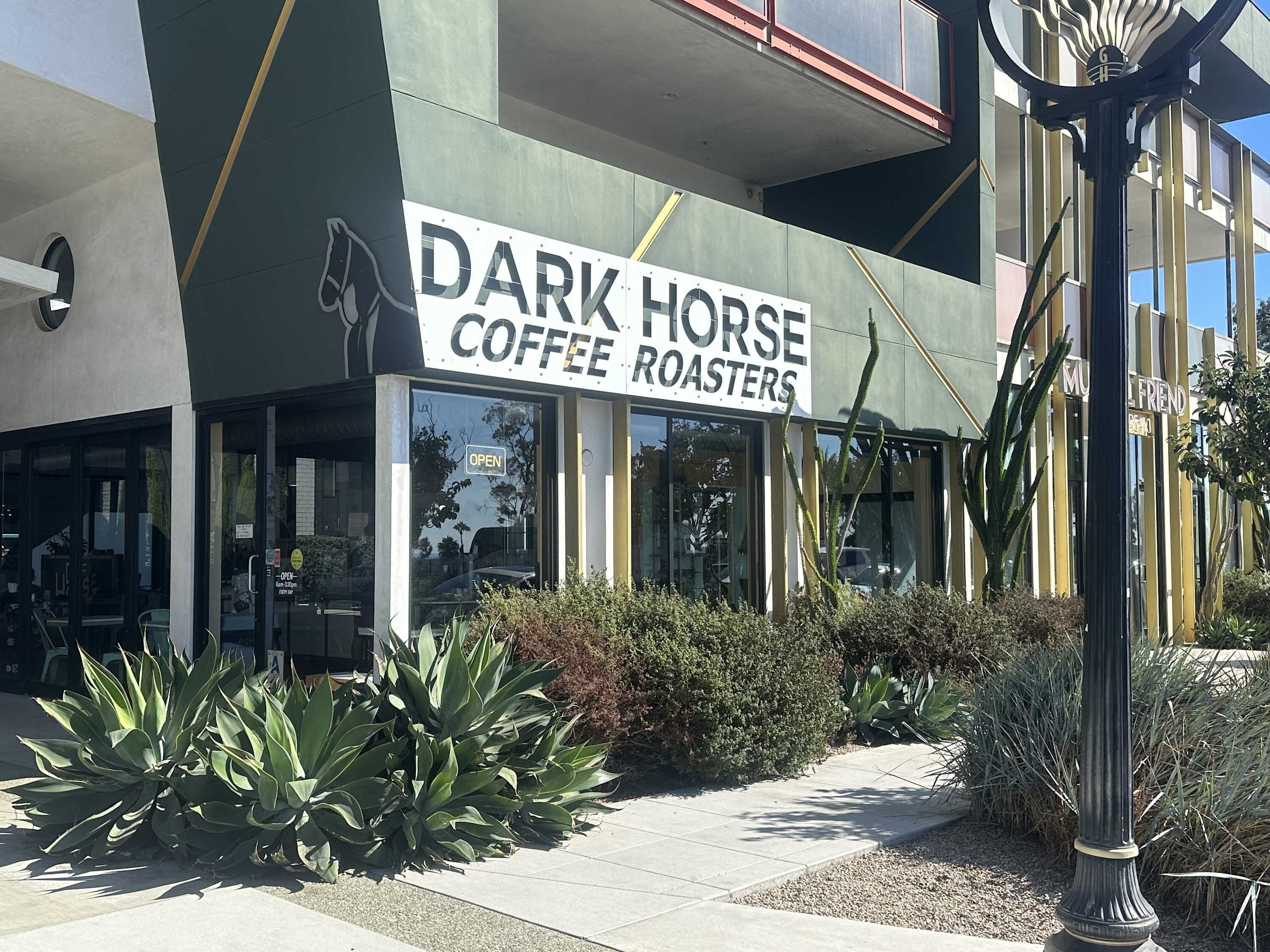 A building with a sign that reads "Dark Horse Coffee Roasters."