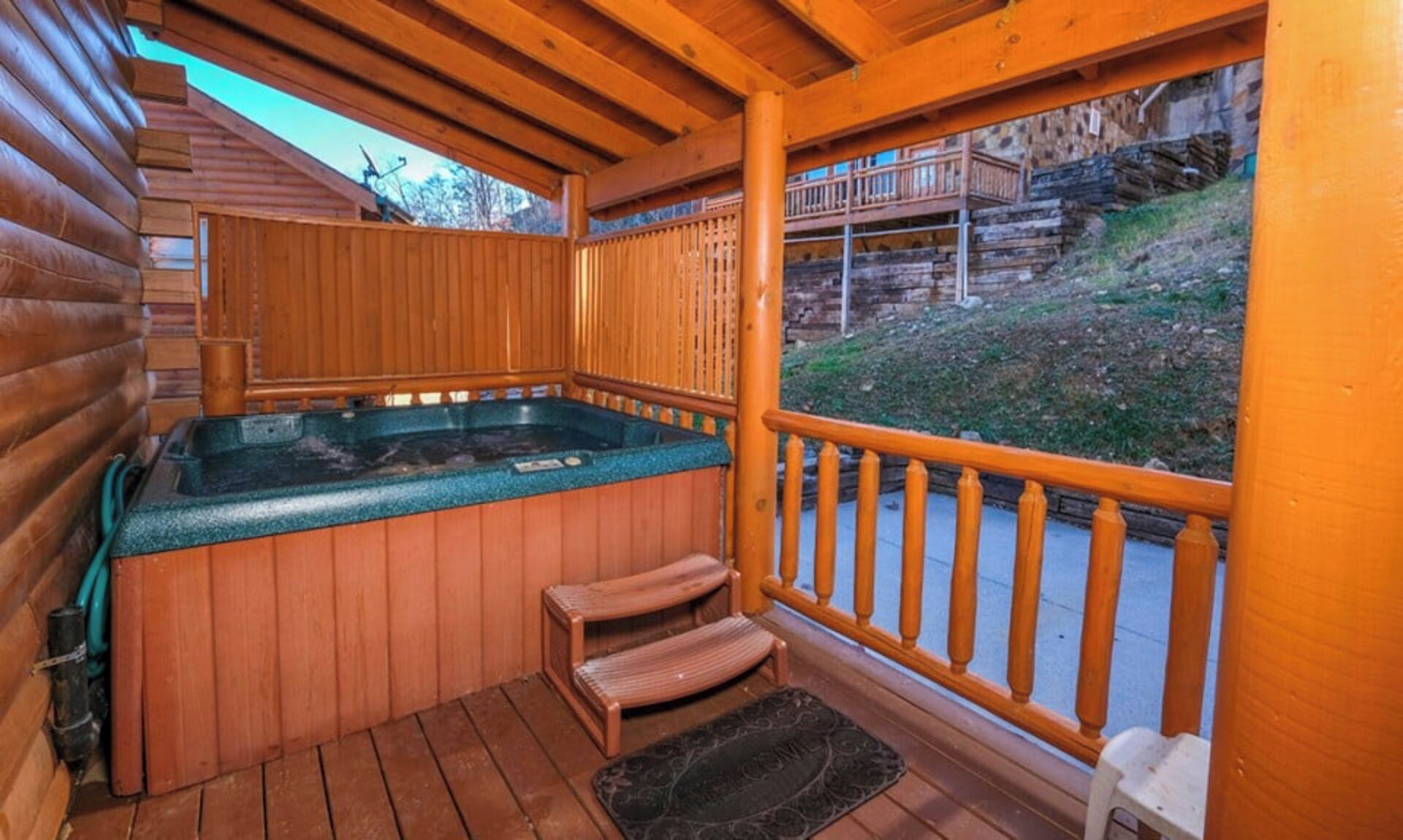 A wooden hot tub with a wooden deck and a view of a mountainous landscape.