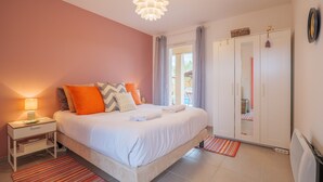 Een slaapkamer met een bed, nachtkastje en een kledingkast.