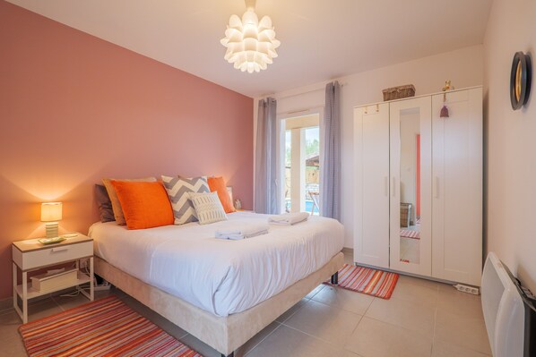 Quarto com cama, mesa de cabeceira e guarda-roupa.