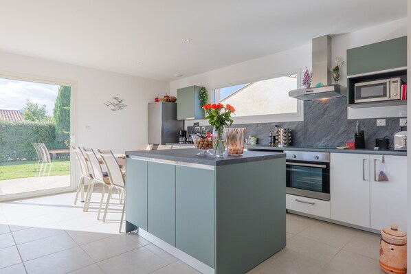 A modern kitchen with a central island, built-in appliances, and a dining area with chairs. - Holiday Home 'Villa M Vallon Pont D'arc' with Private Pool, Wi-Fi and Air Conditioning (Vallon-Pont-d'Arc)
