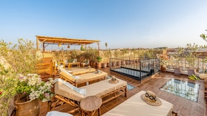 A rooftop terrace with sun loungers, a pergola, and potted plants. - PRIVATE RIAD DAR TOURIA (Marrakesh)