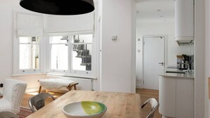 Une cuisine moderne avec des armoires blanches, un four encastré et un évier en acier inoxydable.