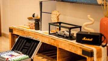 A wooden display table with a television, a small car model, a decorative rock, and a speaker.