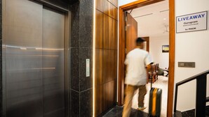 A modern elevator with a metallic finish and a wooden panel design. - LiveAway Gurugram by PACK (Gurugram)
