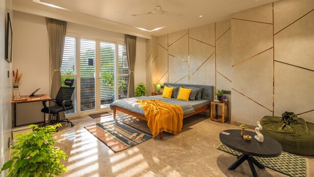 A modern bedroom with a bed, desk, and seating area. - LiveAway Gurugram by PACK (Gurugram)