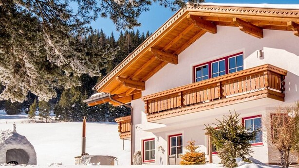 A two-story chalet with a wooden balcony, a snow-covered landscape, and a mountain backdrop. - Matthiasgut - Tauernview S (Radstadt)
