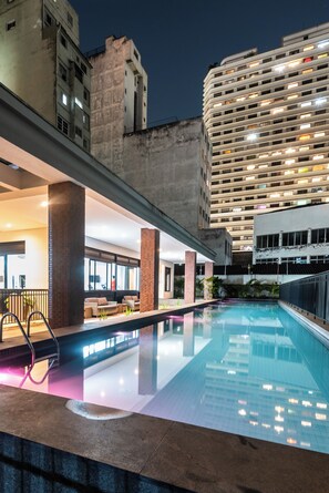 A pool area with a modern design, including a seating area with sofas and a railing. - 88 Rosemari's Apartments: Featuring 2 Bedrooms   (São Paulo)