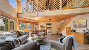 A spacious loft-style living area with high ceilings, wooden beams, and a mezzanine. - Gated Resort Setting*WiFi*Spacious*Hot Tub (Sevierville)