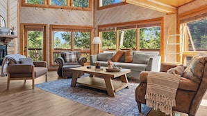 A spacious living room with wooden floors, a large coffee table, and multiple seating options including sofas and chairs. - Gated Resort Setting*WiFi*Spacious*Hot Tub (Sevierville)