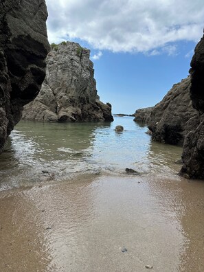 A coastal landscape with rocky formations and calm waters.