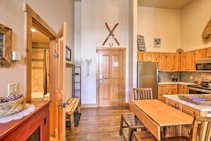 A cozy kitchen with wooden cabinets, a central island, and a dining area with a bench.