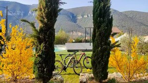 A mountain landscape with a bicycle in the foreground and a building in the background. - Guest Rooms – Château at lesoleilo.com with Shared Pool from 12/06 to 13/09/2026 (Mostuéjouls)