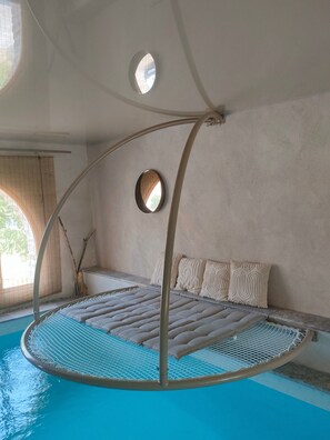 A circular bed with a metal frame, a small round window, and a view of the outdoors. - Guest Rooms – Château at lesoleilo.com with Shared Pool from 12/06 to 13/09/2026 (Mostuéjouls)