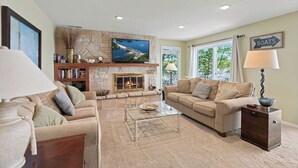 A living room with a fireplace, a television, and a sofa. - Winding Bay - Lakefront with stellar main channel views! (Sunrise Beach)