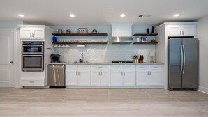 A modern kitchen with white cabinets, stainless steel appliances, and a tiled backsplash. - 2617 Caladium Drive NE, Atlanta (Atlanta)