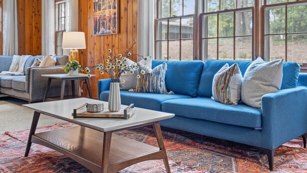 A cozy living room with a blue sofa, a coffee table, and a rug. - 264 Euharlee Rd, Cartersville (Cartersville)