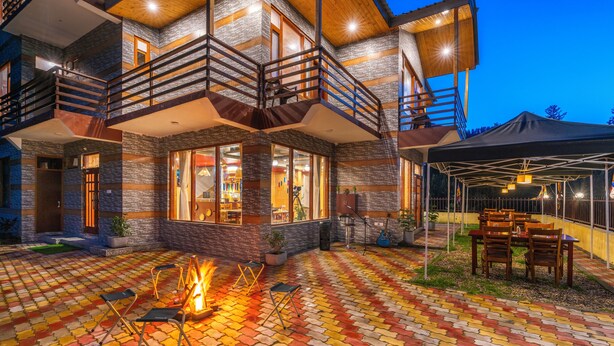 A multi-story building with a balcony, outdoor seating, and a fire pit. - Offbeat Pulga by PACK (Sosan)