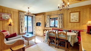 Ein gemütliches Holzinterieur mit Essbereich, einer Couch und einem Tisch mit Stühlen.