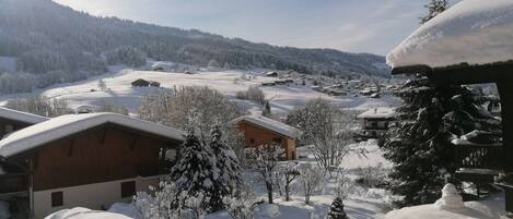 A snow-covered village with wooden houses and a clear sky.