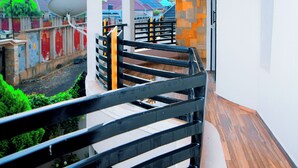 A balcony with a curved railing, a satellite dish, and a view of the surrounding area.