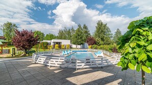 A swimming pool surrounded by a white fence, with benches and a picnic table nearby. - Comfortable Holiday Homes Near the Sea, Pool (Ustronie Morskie)
