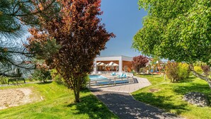 A modern hotel with a swimming pool, surrounded by well-maintained grass and trees. - Comfortable Holiday Homes Near the Sea, Pool (Ustronie Morskie)