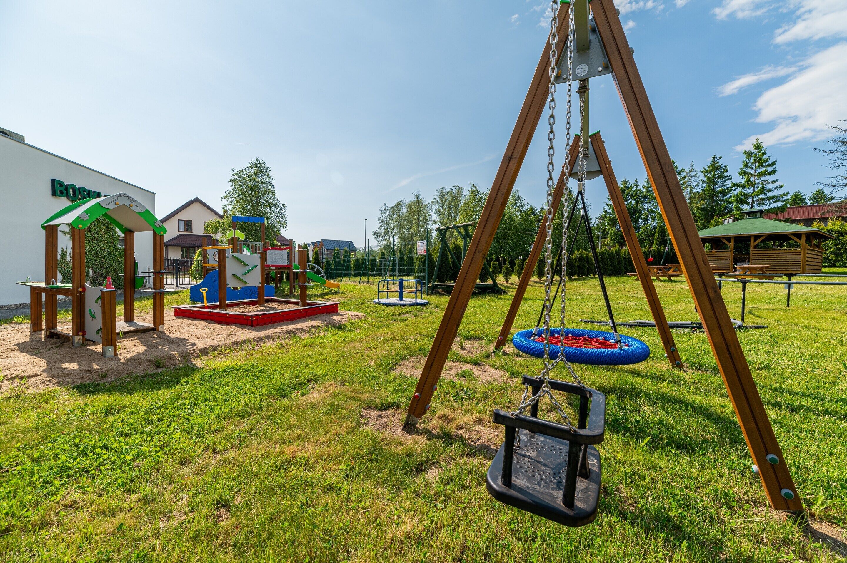 A playground with swings and a climbing structure.
