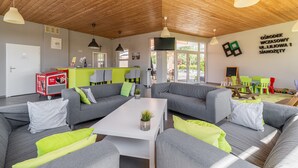 A modern living area with grey sofas, a white coffee table, and a wooden ceiling. - Comfortable Holiday Homes Near the Sea, Pool (Ustronie Morskie)