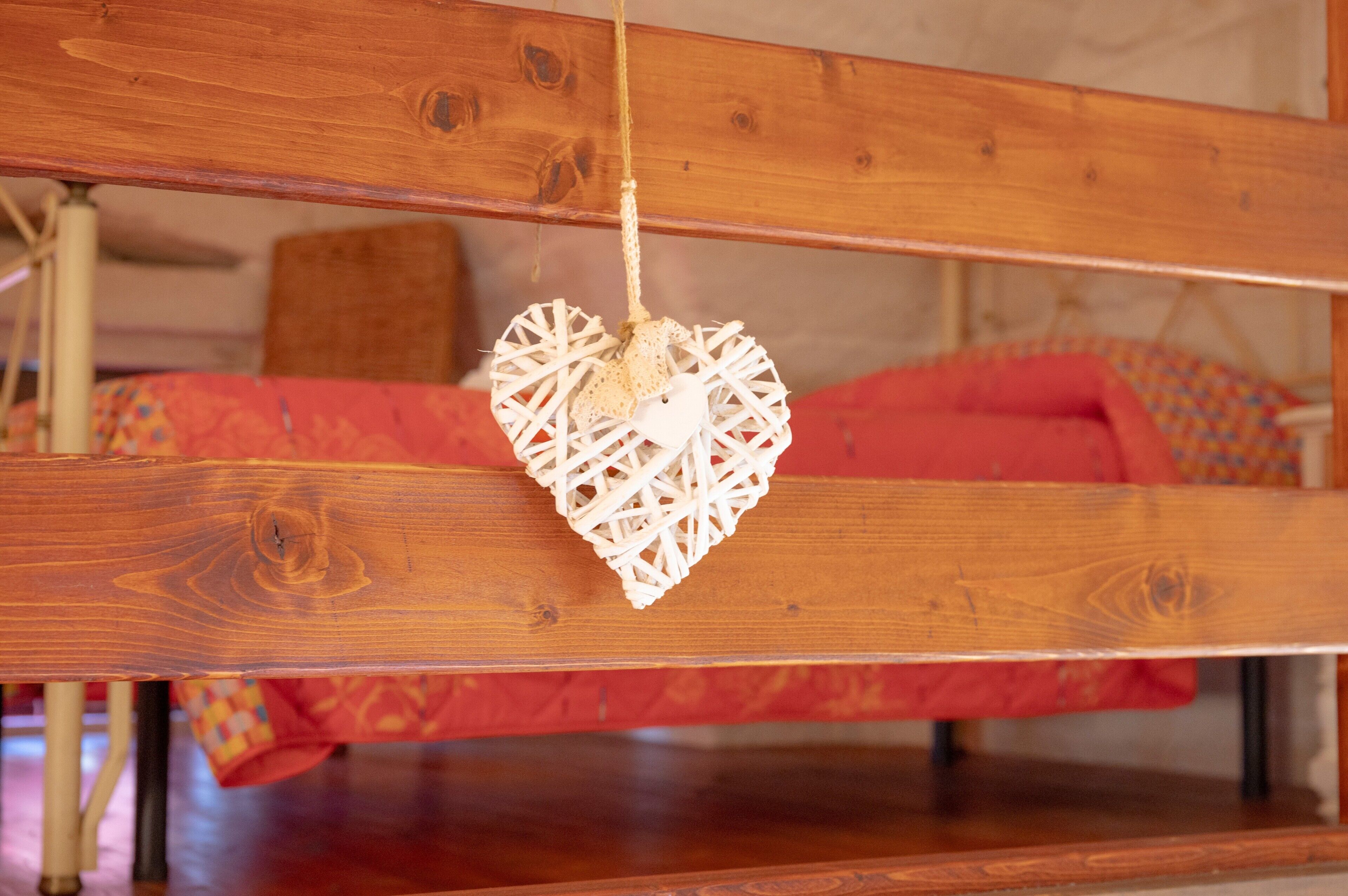 A wooden bench with a hanging heart-shaped decoration.