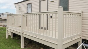 A mobile home with a white deck and a door. - Singh Leite &amp; Luisa Family Caravan (Clacton-on-Sea)