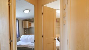 A bedroom with a bed, a wardrobe, and a ceiling light. - Singh Leite &amp; Luisa Family Caravan (Clacton-on-Sea)