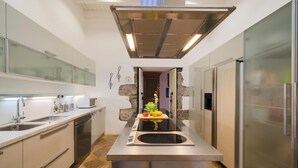 Een moderne keuken met roestvrijstalen apparatuur, een centraal eiland en een ingebouwde oven.
