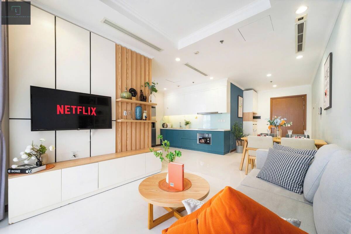 Ein modernes Wohnzimmer mit Fernseher, einer Holzregal und einem runden Couchtisch.