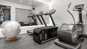 A gym with treadmills, a stationary bike, and a large exercise ball.