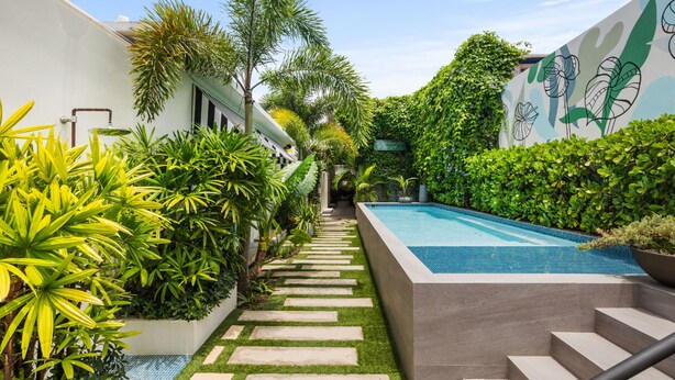 A modern outdoor pool area with a stone pathway leading to a staircase.