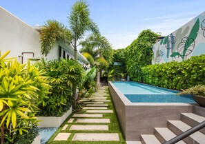 A modern outdoor pool area with a stone pathway leading to a staircase. - Adults Exclusively Bar Oceanpark Beach (San Juan)