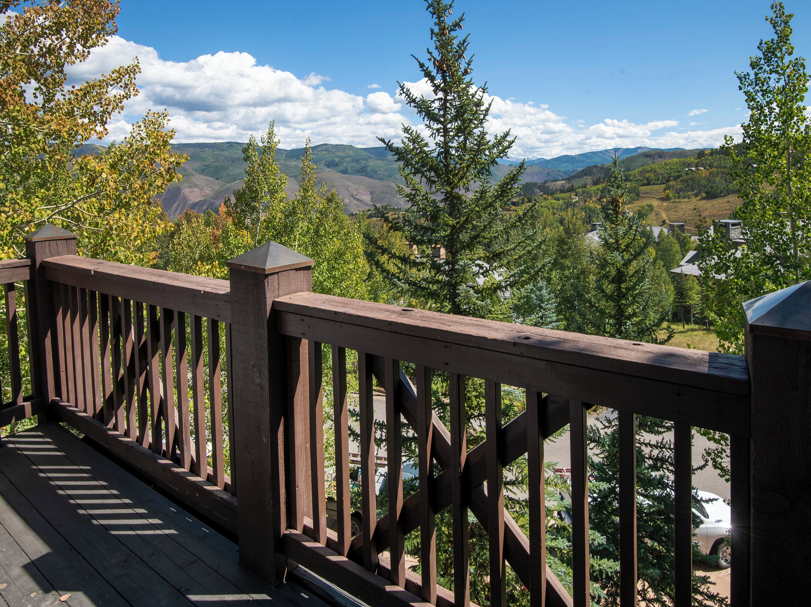 A wooden deck with a view of a mountainous landscape.