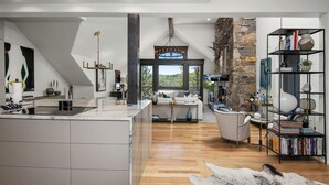 Una cocina moderna con una isla grande, una chimenea de piedra y vistas al exterior.