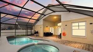 A pool area with a glass ceiling, a hot tub, and a covered seating area.
