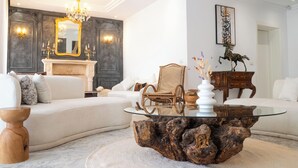 A modern living room with a white sofa, a glass coffee table, a fireplace, and a chandelier. - Villa Victoria La Marsa (La marsa)