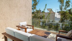 A balcony with a wooden table and white cushioned seating. - Villa Victoria La Marsa (La marsa)