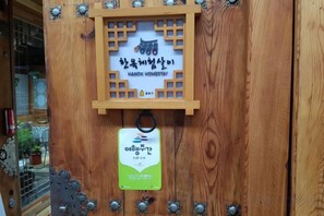 A wooden door with a sign indicating a hand-woven homestay. - Dajayon Hanok Stay (Seoul)