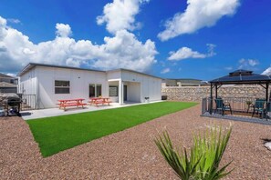 A modern house with a patio, a barbecue area, and a well-maintained lawn. - Texas Modern 4BR 3BA Home Gazebo Spacious Yard (Canutillo)