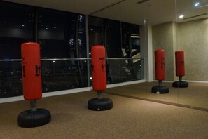 A room with a large window, a glass railing, and four red punching bags. - Mcity Jalan Ampang, KLCC (Kuala Lumpur)
