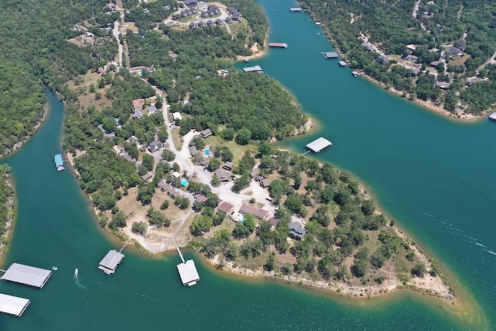 Luchtbeeld van een woongebied met huizen, een steiger en een klein eiland met een boot.