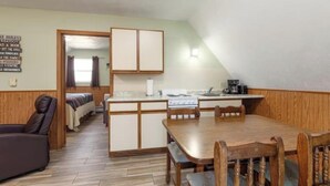 A compact living space with a kitchenette, a dining area, and a bedroom. - Artilla Cove Resort #10 (Branson)